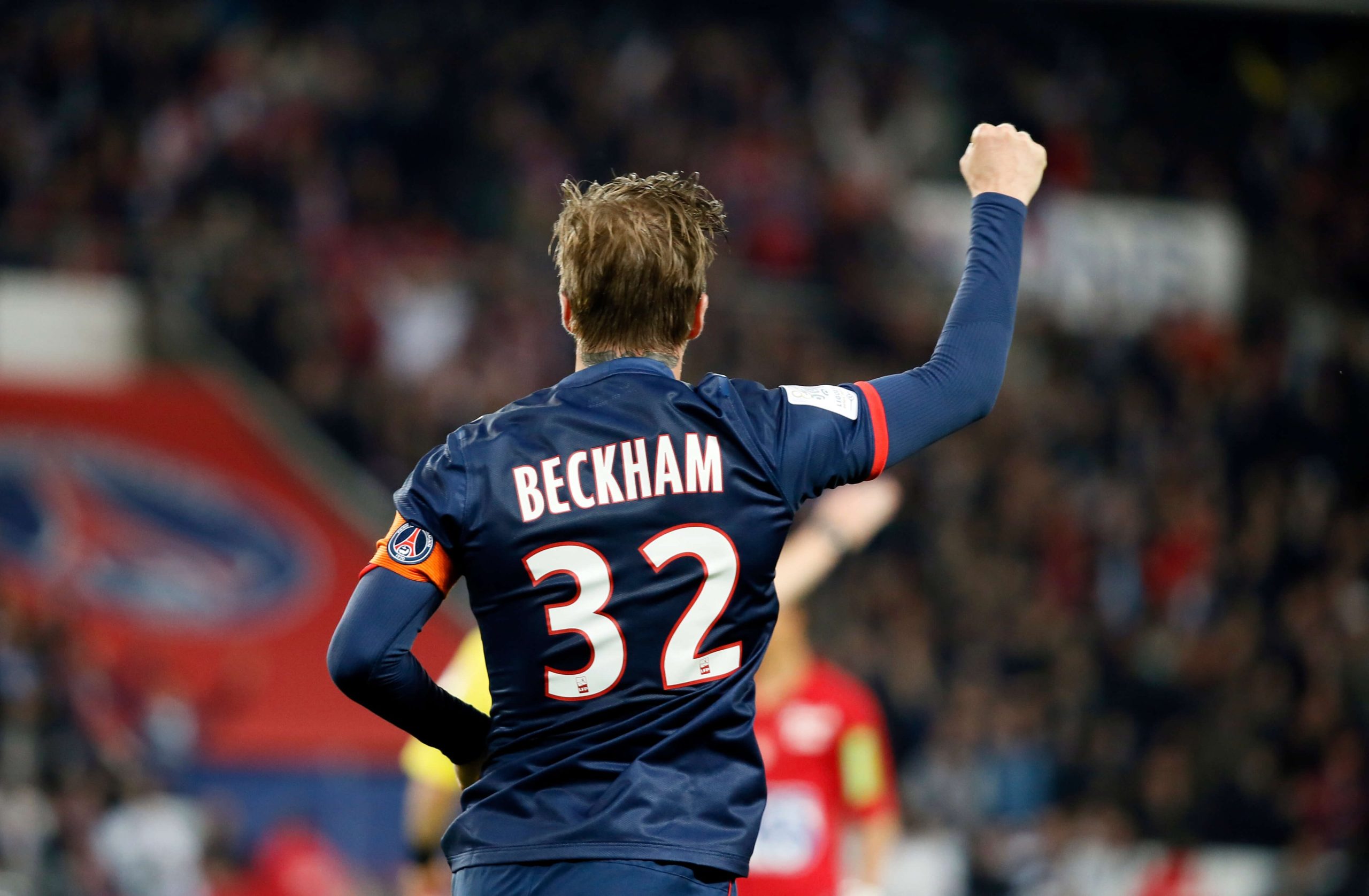 alt text: David Beckham mặc áo số 32 trong màu áo Paris Saint-Germain, chào khán giả sau trận đấu